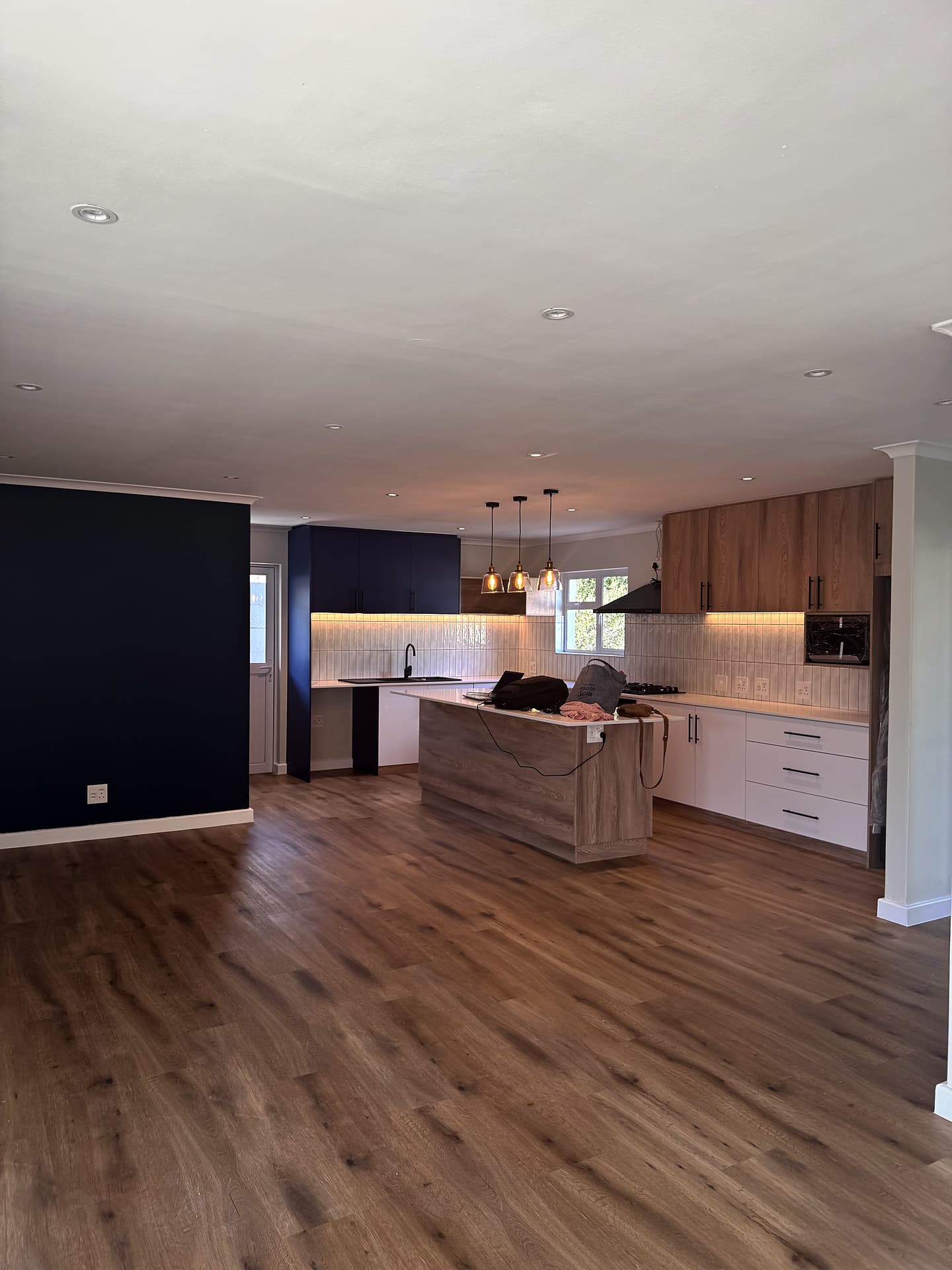 Bloubergstrand – Living room looking into the kitchen, navy feature wall