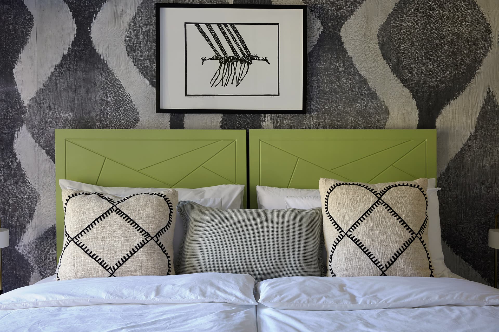 Gardens – Twin green headboards below a framed line drawing, with embroidered cream cushions