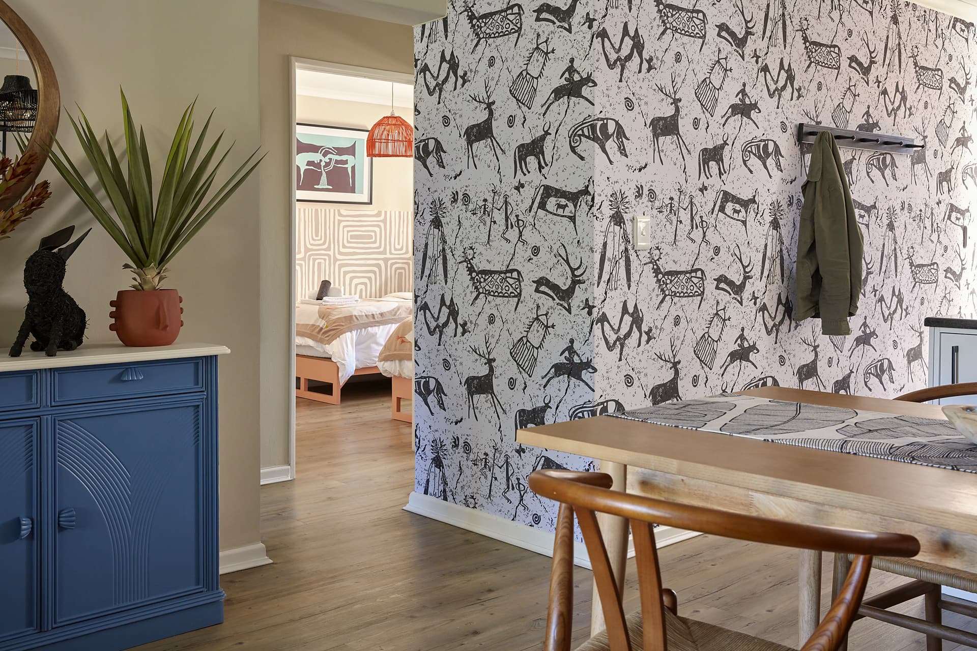 Gardens – Rock-art wallpaper panel beside the blue sideboard, looking through to the twin bedroom