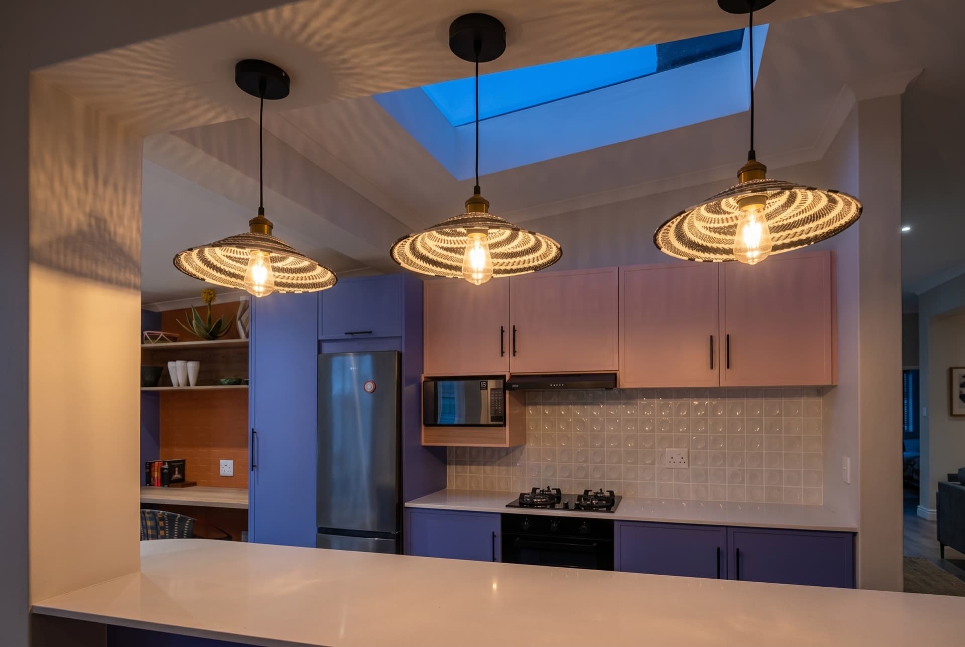 Simon’s Town — the kitchen under its skylight, woven pendants lit