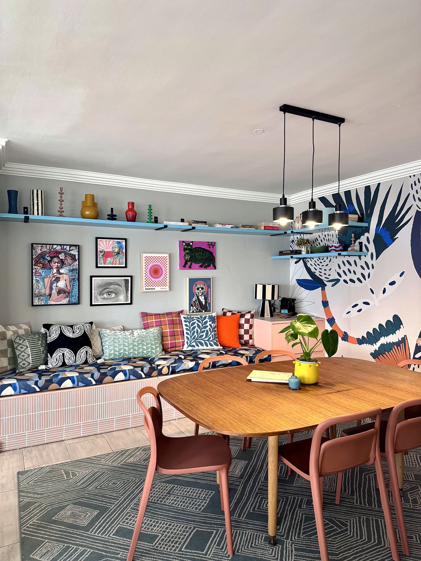Strand – Dining table and banquette against the mural wall
