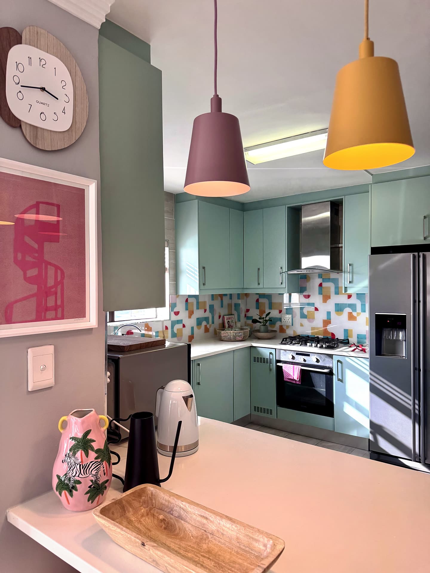 Strand – Clock and two pendants with the kitchen seen through the opening