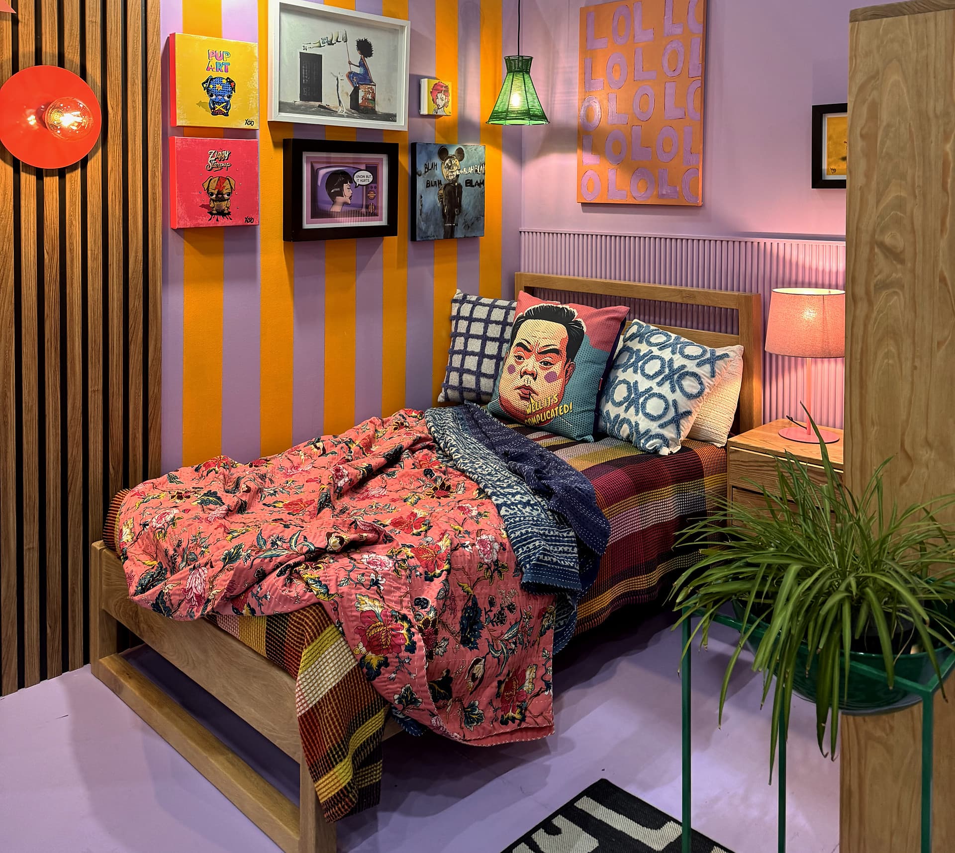 Urban Living Pod – Wide view of the bed, the art wall and a plant stand